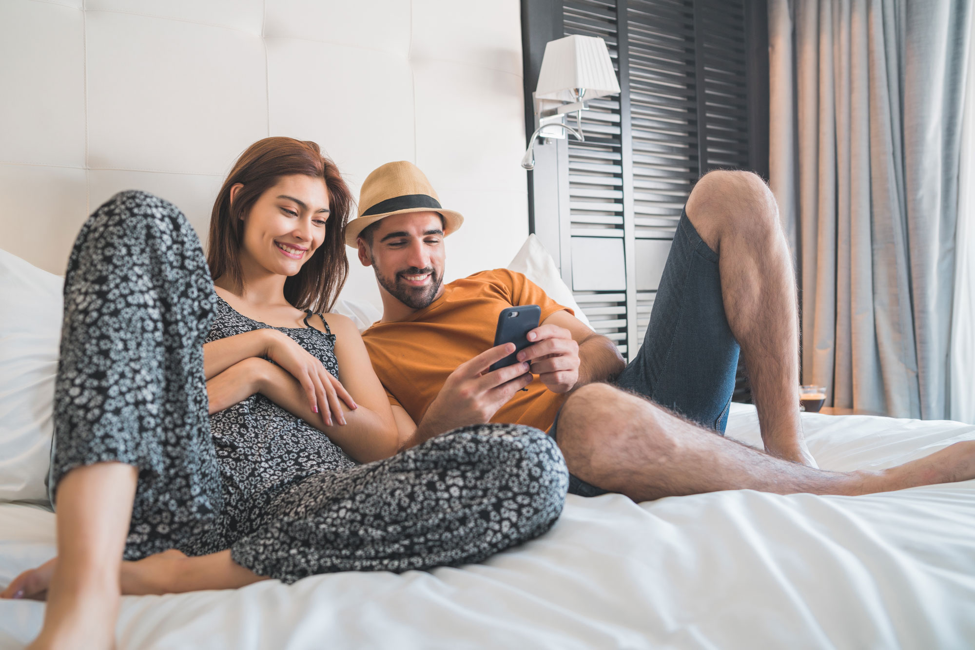 Due ospiti in hotel guardano insieme uno smartphone